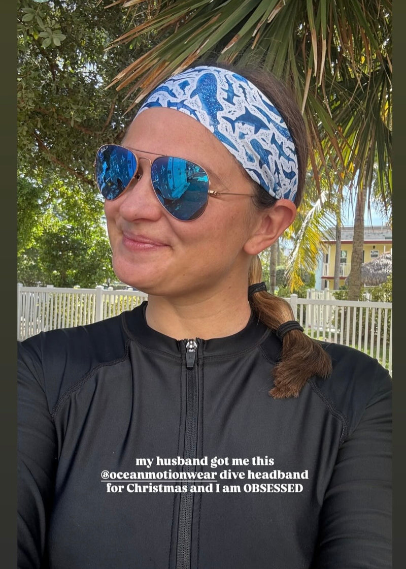 Person wearing a blue and white patterned headband outdoors with trees in the background