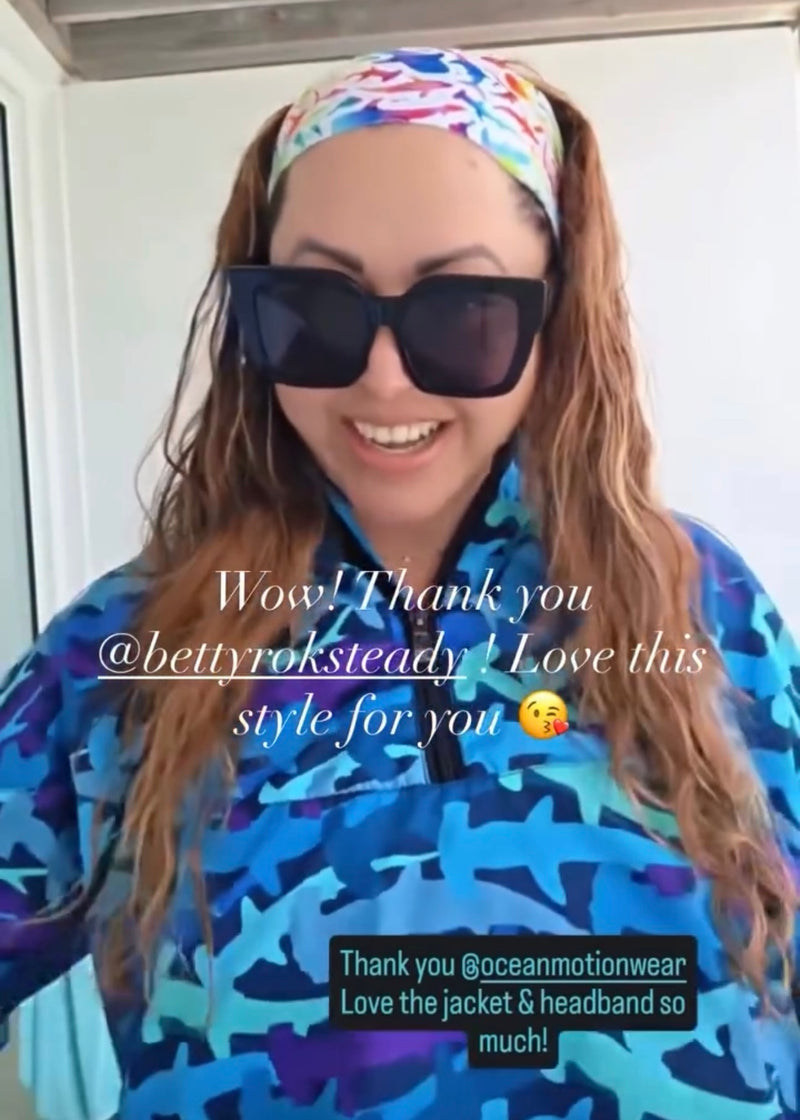 Woman wearing a colorful hammerhead jacket and shark headband with text overlay