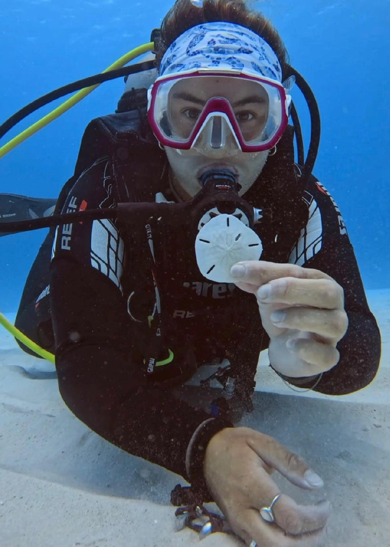 Woman scuba diving underwater wearing a mask and suit and sea turtle headband